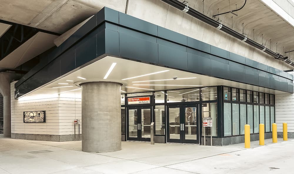 Station doors with dramatic canopy roof and a backlit mural.