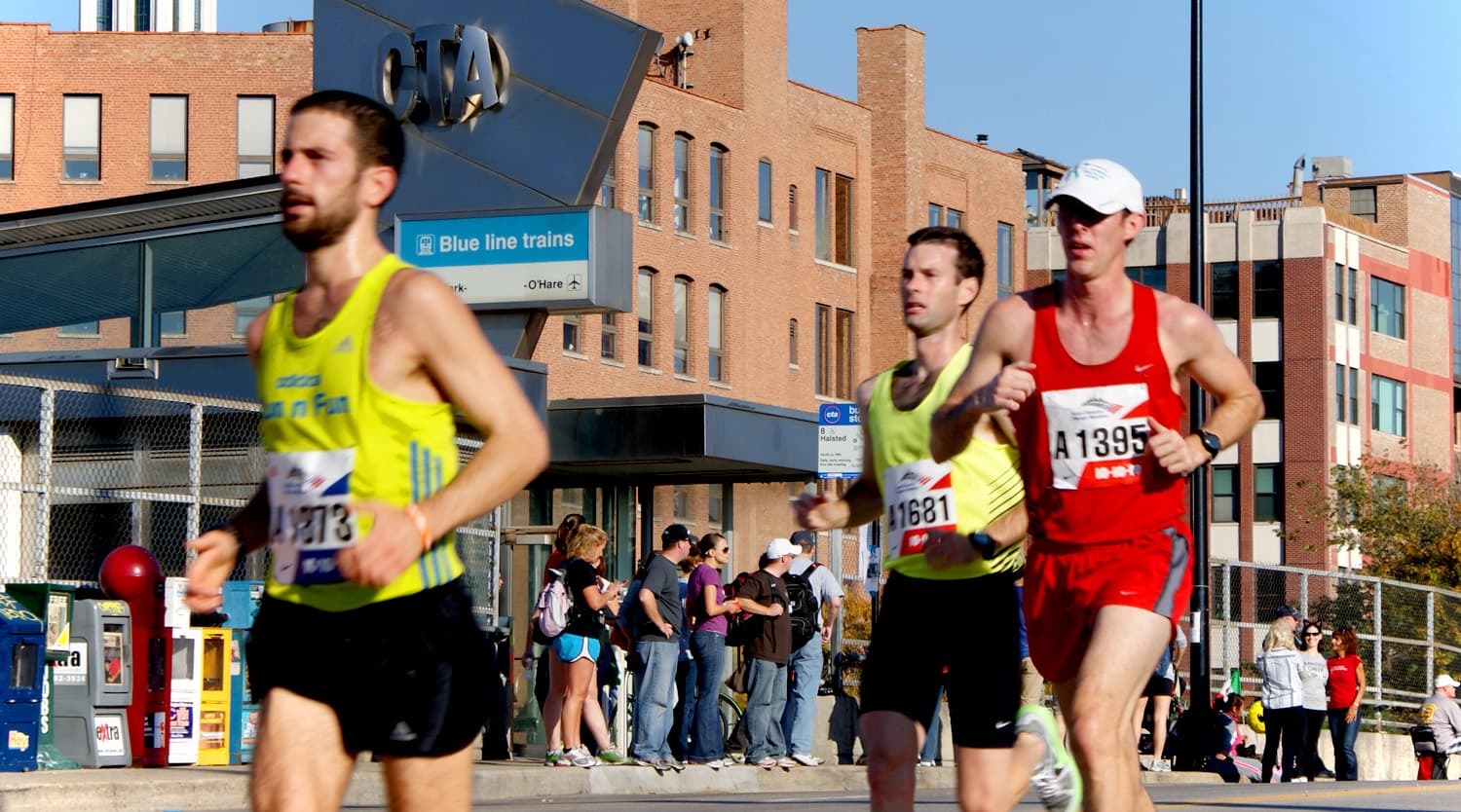 Runners in front of a CTA Blue Line station