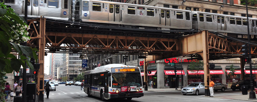 An 'L' train riding above a busy street