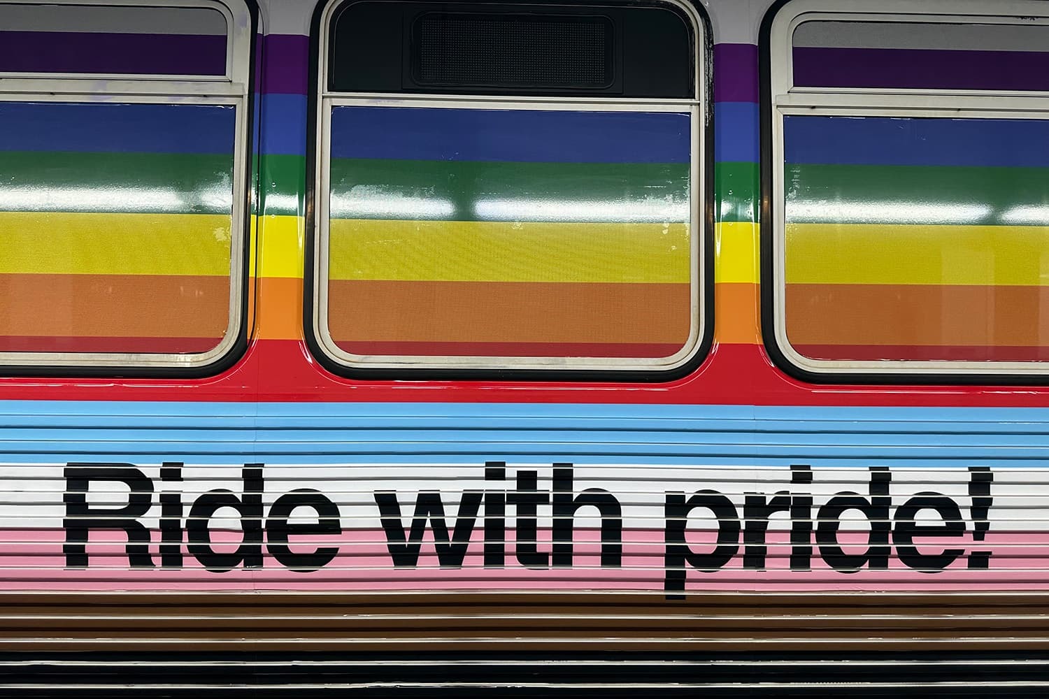 Close up shot on the side of a train car saying Ride With Pride